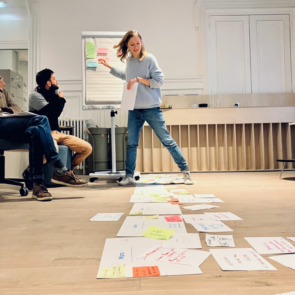 Participants construisant ensemble une réponse commune sur un paperboard